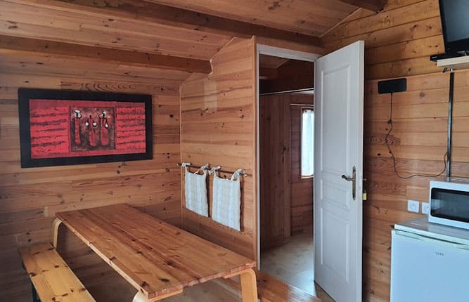 The dining area of the dormitory chalet Le Saint-Léonard for rent at the Escale Occitane campsite near Carcassonne