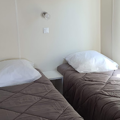El dormitorio con dos camas individuales en el mobil-home Fort de France y Point à Pitre en alquiler en el camping Escale Occitane cerca del Canal du Midi