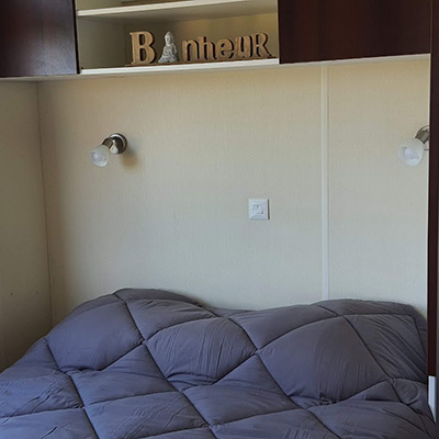 El dormitorio con 1 cama doble en el mobil-home Fort de France y Point à Pitre en alquiler en el camping Escale Occitane cerca de Carcassonne